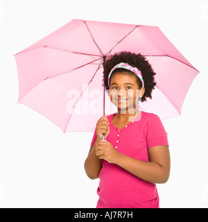 African American Girl holding ombrello rosa sorridente al viewer Foto Stock