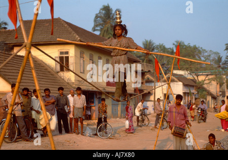 Ragazza giovane musicista di strada a piedi un funambolico, Thiruvanathapuram (Trivandrum), Kerala, India Foto Stock