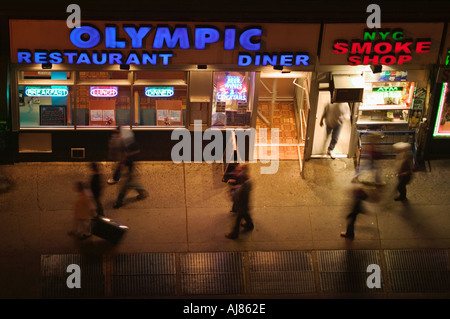 La gente a piedi passato tutta la notte cena sulla Ottava Avenue at 48th Street in Midtown Manhattan New York NY Foto Stock
