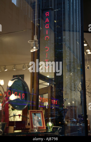 Riflessioni della Radio City Music Hall segni nella finestra di un artigiano americano store su 50th Street vicino a Times Square a New York NY Foto Stock