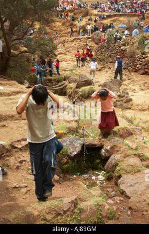 Un ragazzo e una ragazza il lavaggio dei capi in un locale sorgente di acqua al Huacarpay festival di San Salvador nei pressi di Pisac Perù Foto Stock