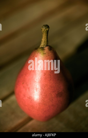 Pera rosso su sfondo di legno Foto Stock