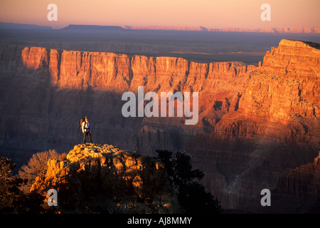 La donna si erge sulla roccia al tramonto. Foto Stock