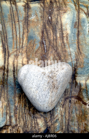 Liscia a forma di cuore contro la pietra di marmo venato rock Foto Stock