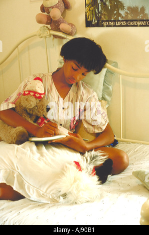 13 year old African American Girl studiano nel letto prima di andare a dormire. St Paul Minnesota USA Foto Stock