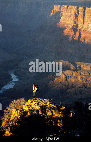 La donna si erge sulla roccia al tramonto nel canyon. Foto Stock