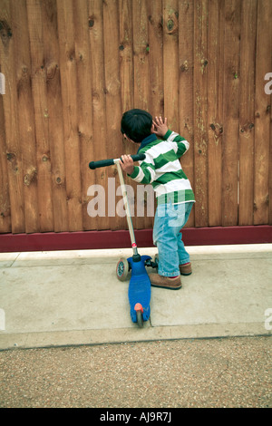 Ragazzo spiata attraverso la recinzione Foto Stock