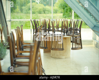 Sedie capovolto su tavole in Cafe Foto Stock