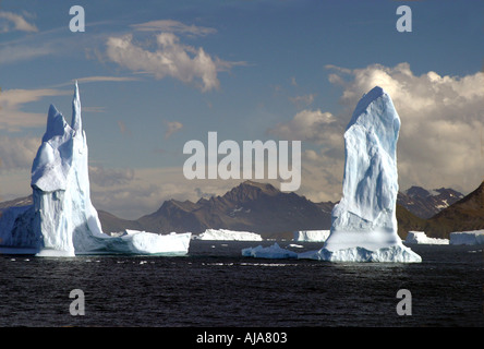 Due spettacolari iceberg scolpito su un mare calmo con le montagne della Georgia del Sud in background Foto Stock