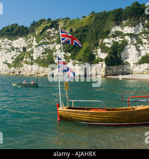 La barca con due Union Jack Flag sorvolare sulla spiaggia di birra Devon England Regno Unito Foto Stock