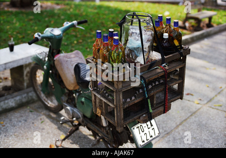 Vino di serpente fornitore di biciclette la città di Ho Chi Minh Saigon Vietnam nota serpenti vivi nel cestello Foto Stock