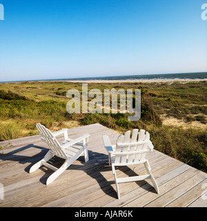 Due poltrone Adirondack sul ponte di legno che si affaccia su Beach a testa calva Isola Carolina del Nord Foto Stock