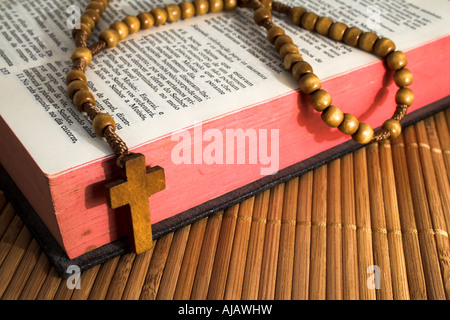 Aprire la Bibbia con rosario su una tabella di paglia Foto Stock