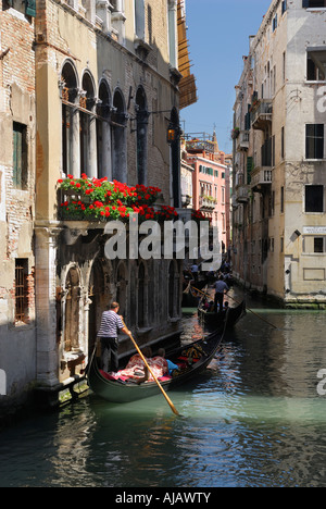 Traffico delle gondole con turisti su uno stretto canale fluviale a Venezia Italia Foto Stock