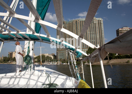 Barca egizia uomo nella tradizionale tunica galibeya su felucca barca a vela con Four Seasons Hotel Cairo Egitto Africa Foto Stock