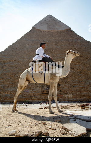 Turismo egiziano poliziotto polizia seduto su un cammello guardia piramidi complesso con la piramide di Chefren Khafre al di là di Giza Cairo Foto Stock