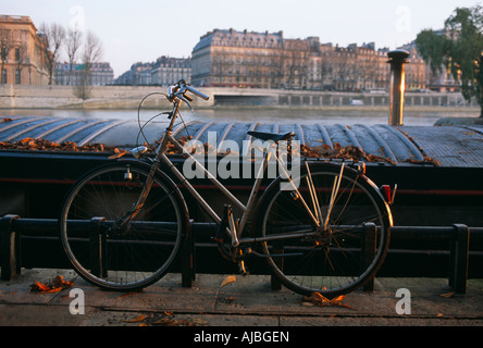 Una fiduciosa proprietario ha lasciato la loro bicicletta sbloccato pendente contro una ringhiera vicino una chiatta sulla riva sinistra della Senna a Parigi Foto Stock