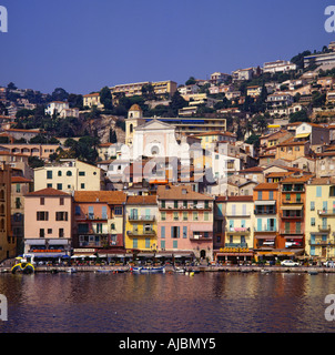 Vista dall'acqua di quayside barche waterfront e città salendo su per la collina a Villefranche-sur-Mer Francia Foto Stock