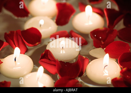 Candele Galleggianti in Acqua Tra Petali Di Rosa Immagine Stock