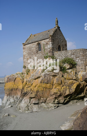 Piccola chiesa di pietra su sperone di roccia dietro il Mont Saint Michel Bretagna Francia Foto Stock
