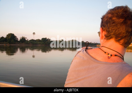 Giovane uomo su una barca - Visualizzazione del Fiume Luangwa al tramonto Foto Stock