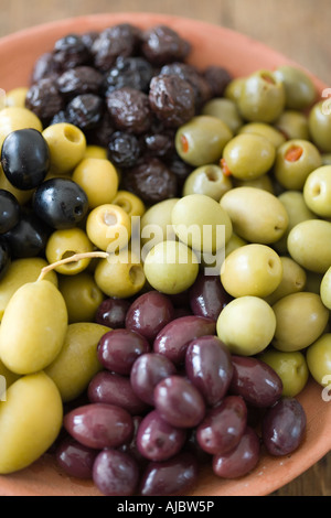 Una raccolta di olive verdi ripiene;Olive Verdi;olive nere e Calamata le olive in un recipiente di ceramica Foto Stock