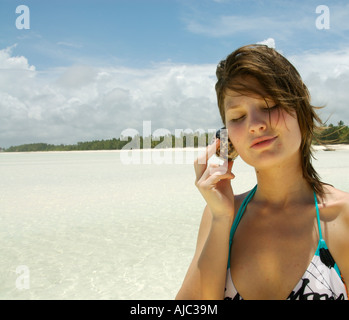 Giovane donna in possesso di una Shell per l'orecchio Foto Stock