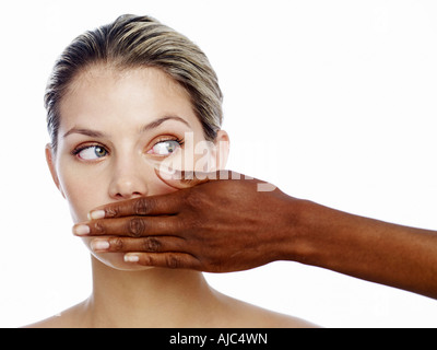 Donna di mano nella parte anteriore di un'altra donna di bocca Foto Stock