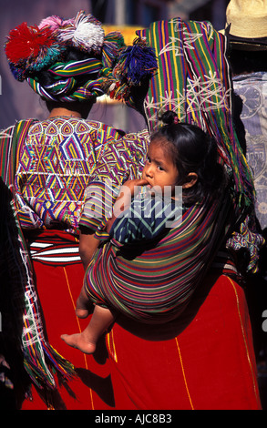 Giovane ragazza Maya viene portato sulla sua schiena delle madri in uno scialle baby carrier Nebaj triangolo Ixil El Quiche Guatemala Foto Stock