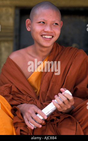 I giovani lo zafferano derubato monaco seduto sui gradini di un tempio Luang Prabang Laos Foto Stock