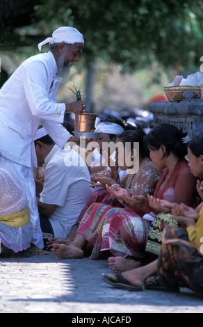 Donne alla cerimonia Indù Pulaki tempio di Bali s N costa è un importante luogo di pellegrinaggio ceremonially riso posto sul fronte Foto Stock