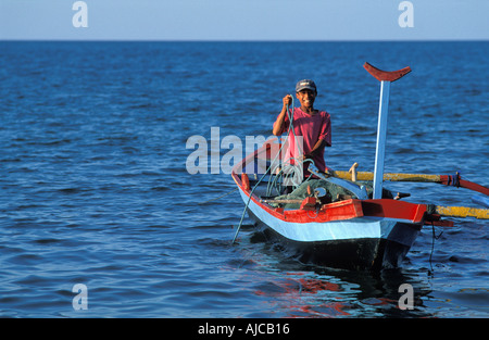 Giovane pescatore Balinese in suo prahu sbarcano Pemuteran una comunità di pescatori di Bali s N coast Foto Stock