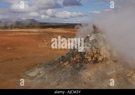 Fumante o fumarola in un paesaggio geotermica con una vista di lontane colline a Hverarond vicino a Myvatn Icelnad del nord Foto Stock