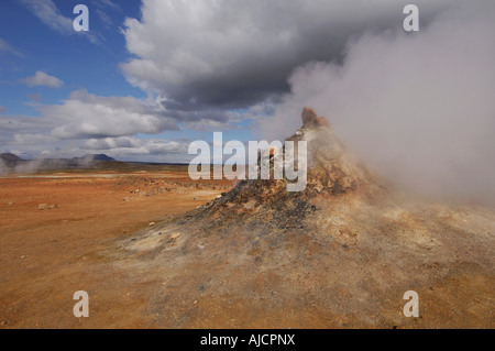 Fumante o fumarola in un paesaggio geotermica con una vista di lontane colline a Hverarond vicino a Myvatn Nord Islanda Foto Stock