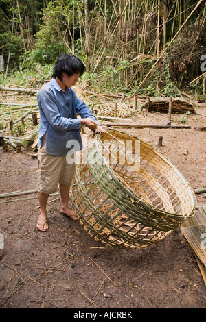 Abitante locale rende cesto in vimini pollo involucro in corrispondenza del Gibbone esperienza vicino a Huay Xai sul fiume Mekong in Laos Foto Stock