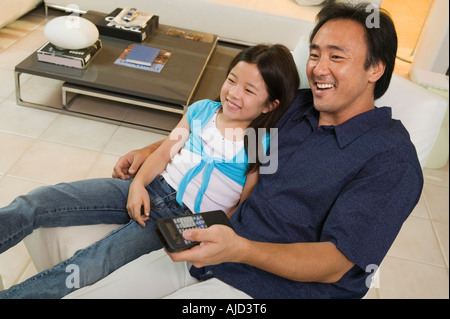 Padre e figlia che guarda il TV in soggiorno, ad alto angolo di visione Foto Stock