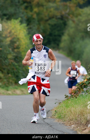 Runner in Kenilworth Mezza Maratona indossando Unione Jack shorts, England, Regno Unito Foto Stock