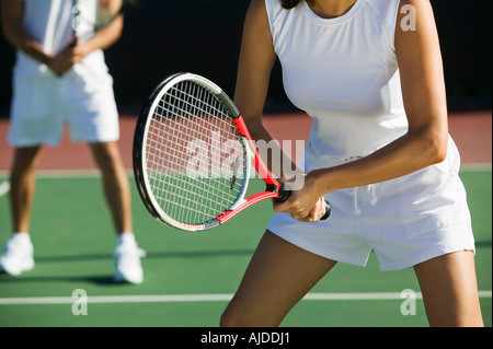 Doppio misto i giocatori di tennis su corte, concentrarsi sulla donna, metà sezione Foto Stock