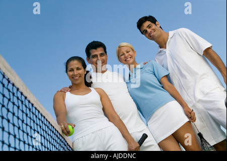 Quattro doppi misti i giocatori di tennis in rete sul tennis, ritratto, basso angolo di visione Foto Stock