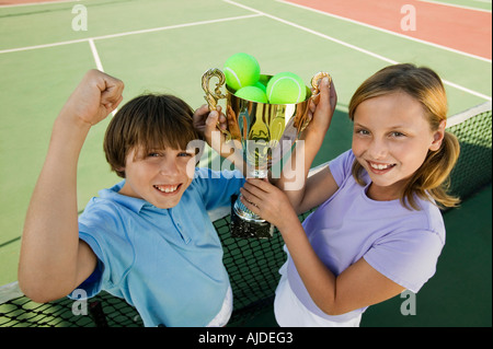 Fratello e Sorella sul campo da tennis tenendo premuto fino trofeo, ritratto, ad alto angolo di visione Foto Stock