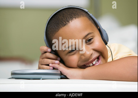 Ragazzo sul divano ascolto di un lettore CD portatile, close up Foto Stock