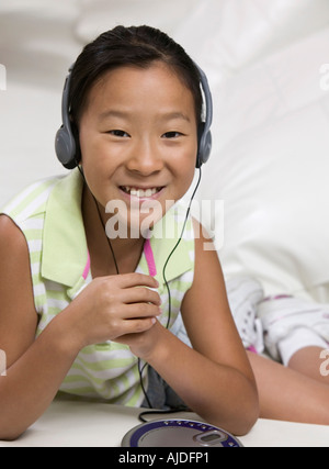 Giovane ragazza sul divano ascolto di un lettore CD portatile Foto Stock