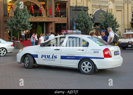 I turisti e la gente locale fuori da un hotel nella popolare Piazza Taksim hanno parcheggiato la macchina della polizia nelle prime ore della scena stradale della sera nella parte europea di Istanbul Turchia Foto Stock