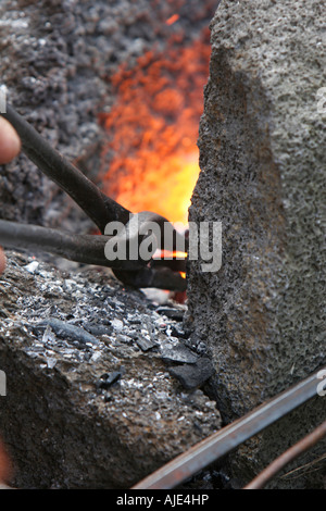 Metallo essendo riscaldato in una fucina da fabbro Foto Stock