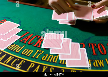 Le mani di una donna croupier che trattano le schede Foto Stock