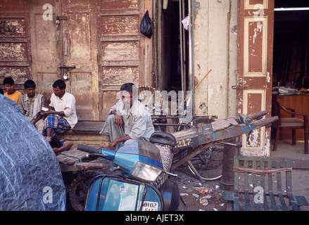 Gli uomini seduti in street , Mumbai, India Foto Stock