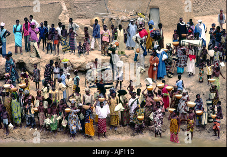 Città di Diafarabe sul Fiume Niger e Mali. I commercianti vendono latte, stuoie tessute e frutta per gli acquirenti di avvicinamento al traghetto passeggeri Foto Stock