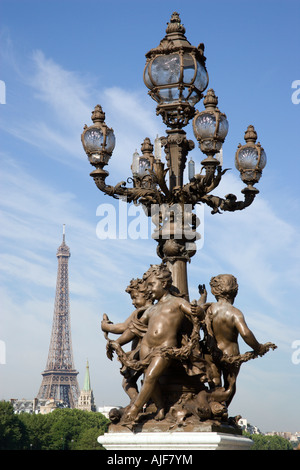 Francia Ile de France Parigi lampione in bronzo con putti sul Pont Alexandre III ponte sul Fiume Senna con la Torre Eiffel al di là Foto Stock