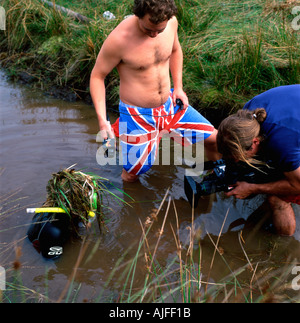 Uomo con Union Jack trunk di nuoto e la videocamera al mondo Bog Snorkelling campionati di Llanwrtyd Wells Powys Wales UK KATHY DEWITT Foto Stock