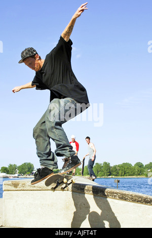 Teenage pratiche maschio salta trucchi e maneouvers su uno skateboard Foto Stock